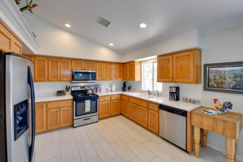 a kitchen with wooden cabinets and white appliances at Updated Abode 22 Mi to Joshua Tree National Park! in Morongo Valley