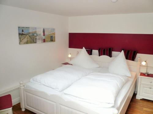 ヴェスターラントにあるFriesenhaus-App-3の白い枕が付いた大きな白いベッド