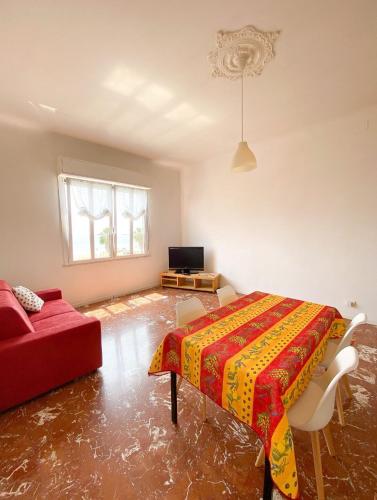 a bedroom with a bed and a red couch at La casetta di nonno Vittorio in Albissola Marina