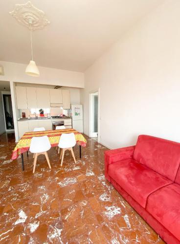 a living room with a red couch and a table at La casetta di nonno Vittorio in Albissola Marina
