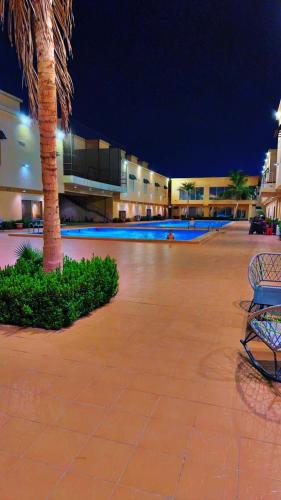 a palm tree and a bench in front of a building at سويت ابحر سكن خاص SUITE OBHUR private accommodation in Jeddah