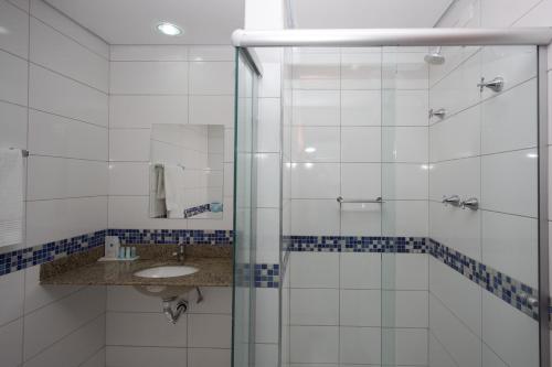 a bathroom with a glass shower and a sink at Bristol Exceler Campo Grande in Campo Grande