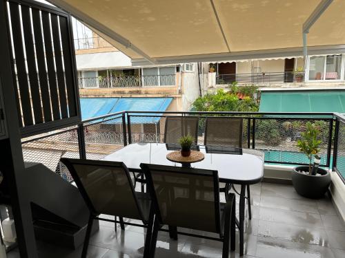 balcone con tavolo, sedie e vista sulla piscina di Vamelon ad Atene