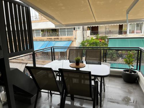 a balcony with a table and chairs and a view of a pool at Vamelon in Athens