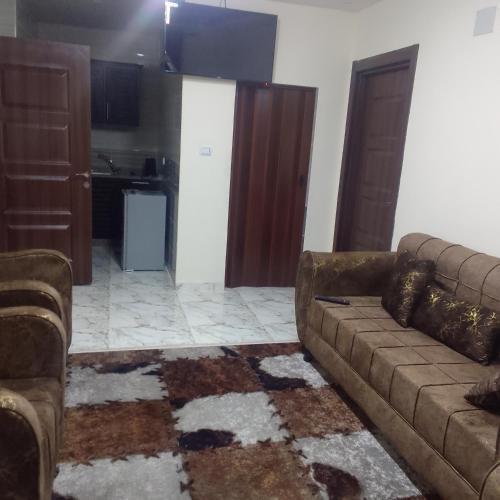 a living room with a couch and a kitchen at Dream house hotel jerash in Jerash