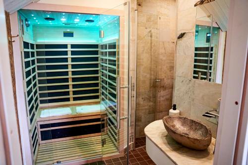 La salle de bains est pourvue d'un lavabo et d'une douche en verre. dans l'établissement Borghamn Strand, à Borghamn