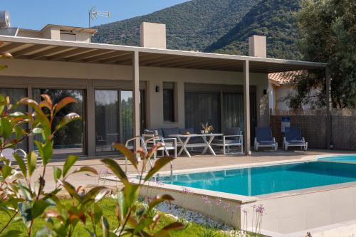 a villa with a swimming pool and a house at Averto Villas with private pool in Nydri