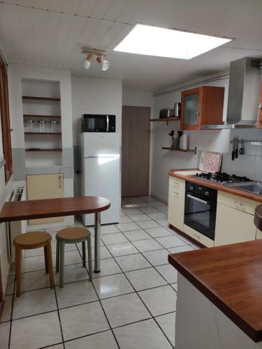 une cuisine avec une table, des chaises et un réfrigérateur dans l'établissement Maison cosy au cœur de la vieille ville, à Boulogne-sur-Mer