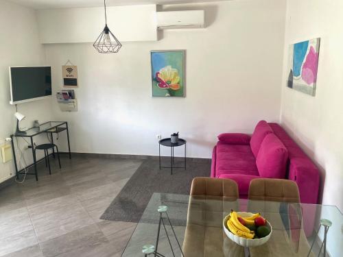 salon z różową kanapą i szklanym stołem w obiekcie Tijara Apartment w mieście Rijeka
