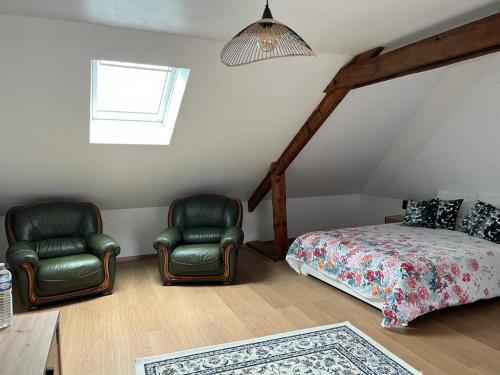 a bedroom with two chairs and a bed and a window at La Maison des Amis en Normandie in Pontfarcy