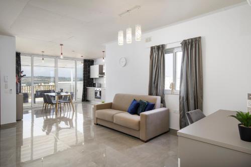 - un salon avec un canapé et une table dans l'établissement Hilltop Apartments - Stylish Comfort Living close to the sea, Bugibba, à San Pawl il-Baħar