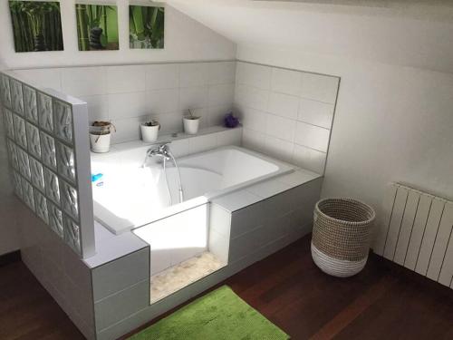 Maison de ville 5 chambres, piscine في بورت-ليه-فالونس: حوض استحمام كبير أبيض في حمام به سجادة خضراء