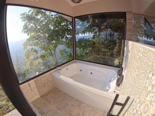 a bath tub in a room with large windows at Eco Lodge SOL- SUE in La Mesa