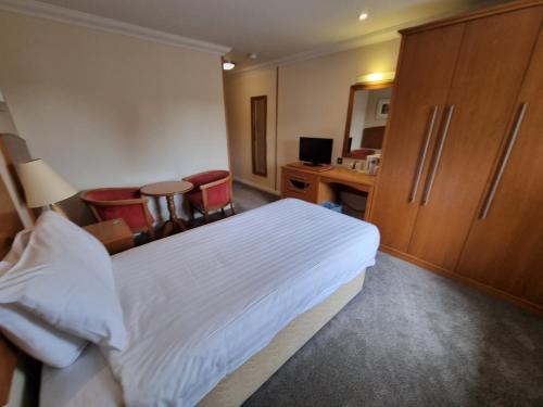 a hotel room with a bed and a desk at Kegworth Hotel & Conference Centre in Castle Donington