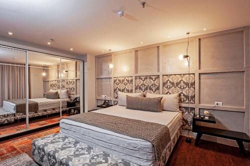 a bedroom with a large bed and a mirror at Brut by Slaviero Hotéis in Balneário Camboriú