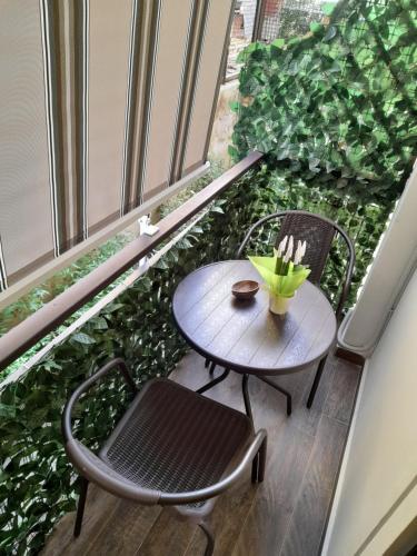 una mesa y sillas en un balcón con plantas en L'Oasi di Venere Bed and Breakfast en Caserta