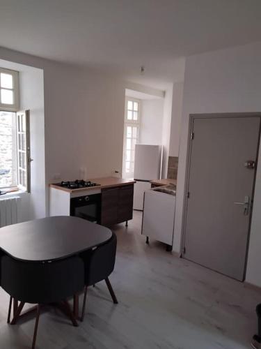 Habitación con cocina con mesa y puerta. en Appartement cœur de ville en Tréguier