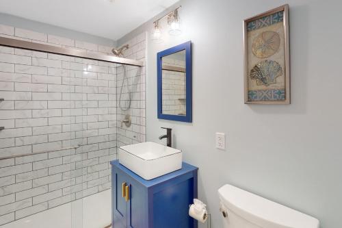 a bathroom with a blue sink and a toilet at Bayside on Commercial in Provincetown