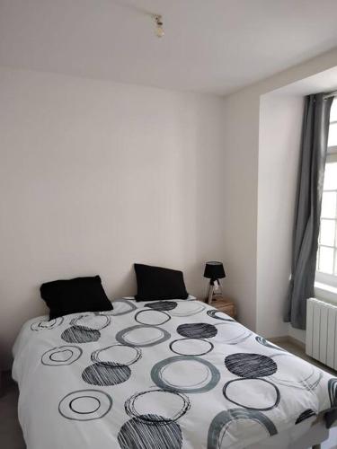 Un dormitorio con una cama con una manta. en Appartement cœur de ville en Tréguier