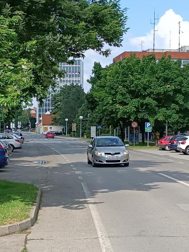 a car is driving down a city street at Apartman Vervis Varaždin in Varaždin