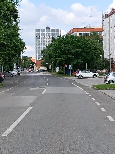 an empty street with cars parked on the road at Apartman Vervis Varaždin in Varaždin