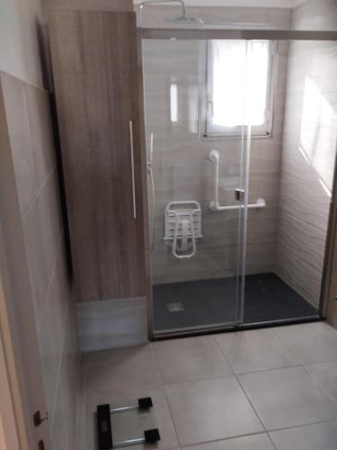La salle de bains est pourvue d'une douche avec une porte en verre. dans l'établissement appartement 4 couchages renovés entièrement, à Cavaillon