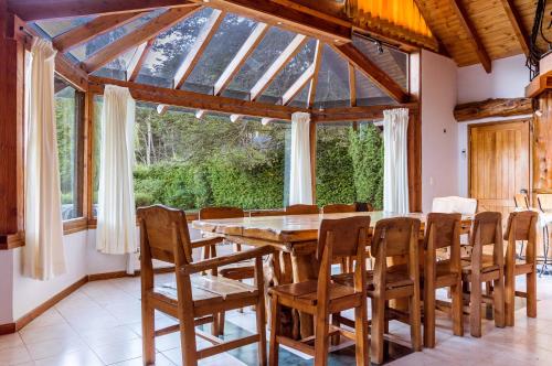 comedor con mesa de madera y sillas en BOG Casa Glorieta - casa 4 cuartos en Villa La Angostura