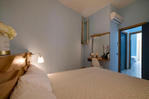 a bedroom with a bed and a desk and a door at Vento Verde Apartments in Sperlonga