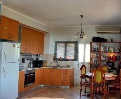 a kitchen with wooden cabinets and a white refrigerator at Relaxing Country house Porto Vito in Porto Germeno