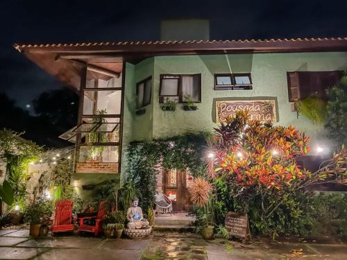 a woman sitting outside of a house at night at Pousada Santarina in Florianópolis