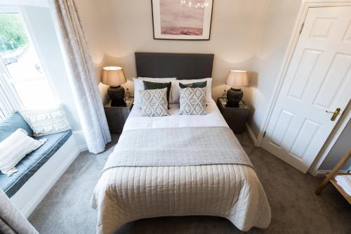 a bedroom with a bed and two lamps and a door at The Hope & Anchor Restaurant & Rooms in Ross on Wye