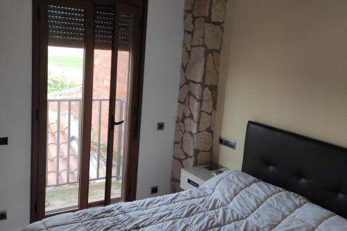 a bedroom with a bed and a view of a balcony at Ca Serrulleta in Ascó
