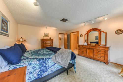 a bedroom with a bed and a dresser and a mirror at Cloudcroft Mtn Home with Patio, Walk to Golf Course! in Cloudcroft