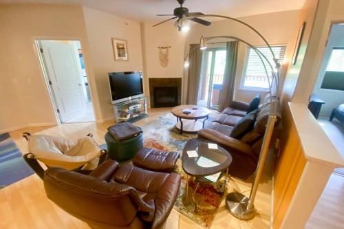a living room with leather furniture and a flat screen tv at Creekside Retreat C203 in Girdwood