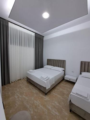 a bedroom with two beds in a room at VILA PUSHIMI REGIS in Velipojë