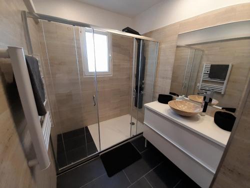 a bathroom with a glass shower with a sink and a counter at villa individuelle in Bagnols-sur-Cèze