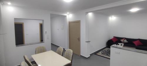 a dining room with a white table and chairs at Logement familial 2 in Selouane