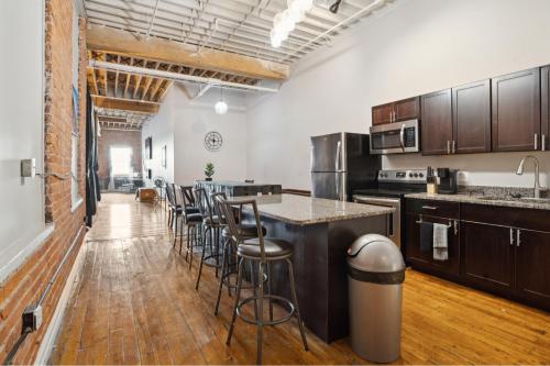 a large kitchen with a counter and bar stools at Gorgeous Downtown Detroit Loft - Fully Equipped in Detroit