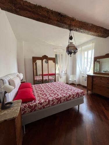 a bedroom with a bed with red sheets and a mirror at La casa di Martina a San Pè in Castiglione Chiavarese