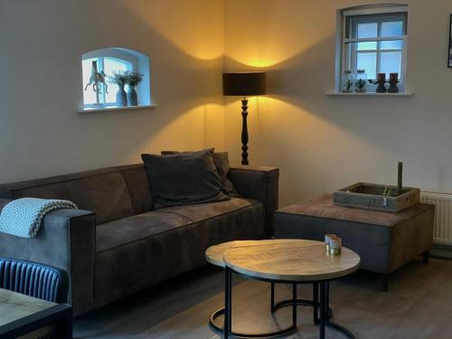 un soggiorno con divano e tavolo di Restful Holiday Home with a Private Terrace and hottub a Veendam