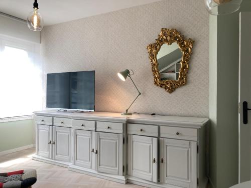 a white dresser in a room with a mirror at Luarca Experience in Luarca