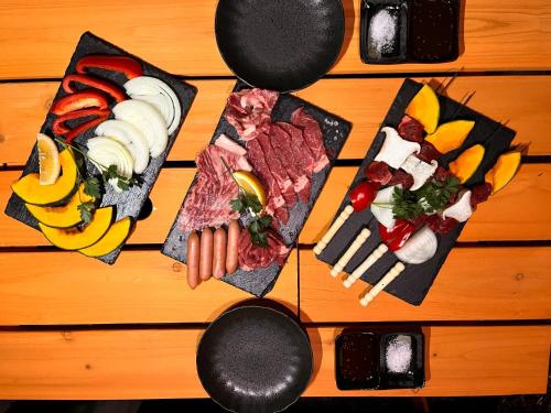 een tafel met verschillende soorten levensmiddelen op borden bij Glamchette Okayama -Glamping & Auto Camp- - Vacation STAY 44593v in Mimasaka