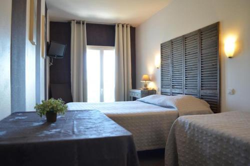 ラ・ロシェルにあるHôtel de l'Océanのベッド2台とテーブルが備わるホテルルームです。