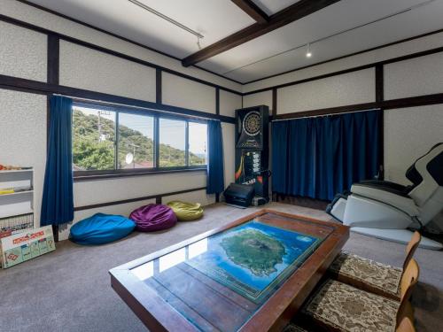ein Wohnzimmer mit einem Tisch und einem Sofa in der Unterkunft Yuraku Izu-Oshima - Vacation STAY 44742v in Oshima