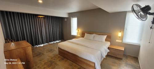 a bedroom with a large bed and a window at Castra villas in Vandiperiyār