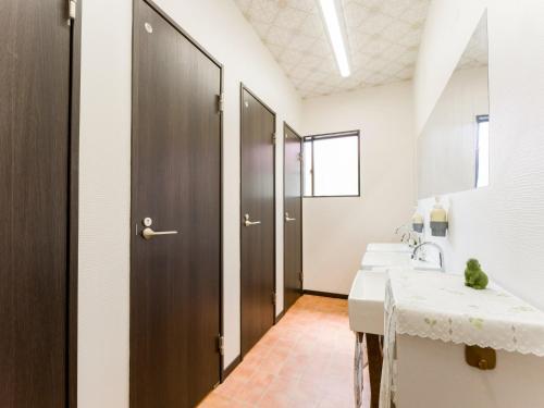 ein Badezimmer mit zwei Waschbecken und einer Holztür in der Unterkunft Yuraku Izu-Oshima - Vacation STAY 44742v in Oshima