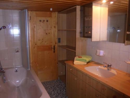 y baño con bañera, lavamanos y ducha. en Ferienhaus Nussbaumer en Sibratsgfäll