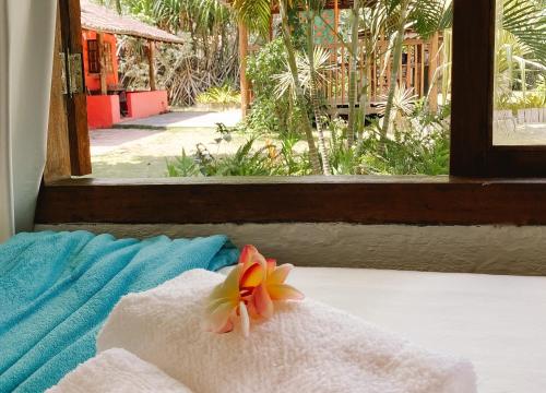 a towel with a flower sitting on top of a window at Bangalôs da Aldeia Caraiva in Caraíva