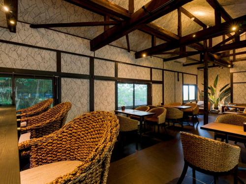 um restaurante com cadeiras de vime, mesas e janelas em Yuraku Izu-Oshima - Vacation STAY 44711v em Oshima