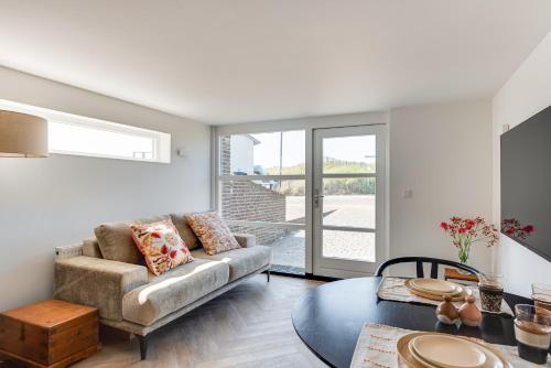 ein Wohnzimmer mit einem Sofa und einem Tisch in der Unterkunft Zeezicht Villa Duin vlak bij strand en zee in Bergen aan Zee